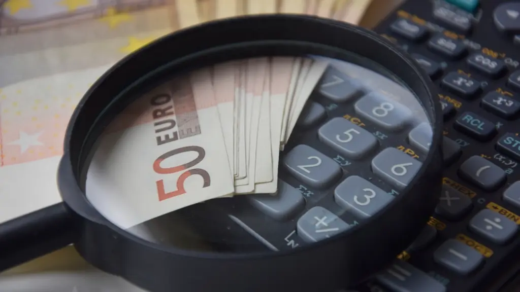 Euro banknotu ve hesap makinesinin üzerinde büyüteç